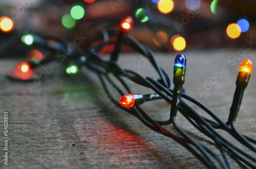 Christmas garland lights on wooden rustic background.Selective focus.Winter holidays concept. © svf74