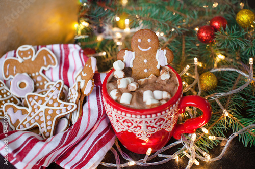 Red mugs with hot chocolate and marshmallows and gingerbread cookies. Christmas holiday concept