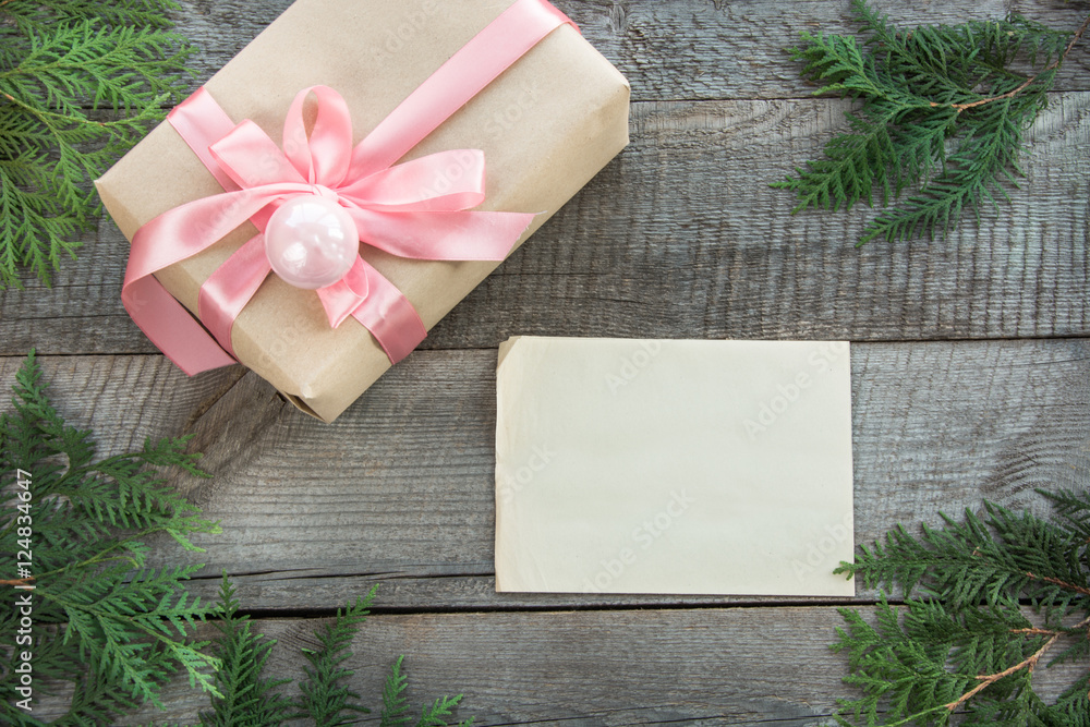 Obraz premium Preparation for Christmas holiday. Christmas gift box with pink ribbon and decor. Blank for you greetings, wishes. Top view and copyspace. Flat lay.