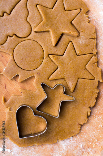 Cookies forms and gingerbread dough on wooden pastry board