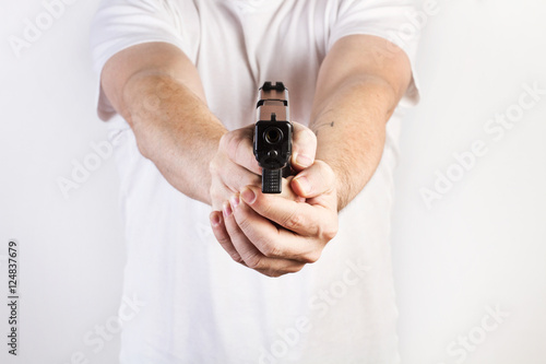 Manos de hombre sosteniendo y apuntando un arma pistola. Vista de frente. Concepto Problemática social