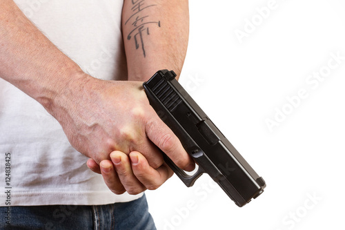 Manos de hombre sosteniendo un arma pistola en un fondo blanco. Vista de frente y de cerca. Copy space. Concepto: Problemática social