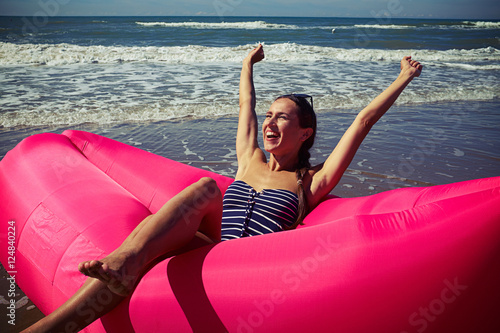 A female rejoicing on a deep-rosy air rubber boat upping her han photo