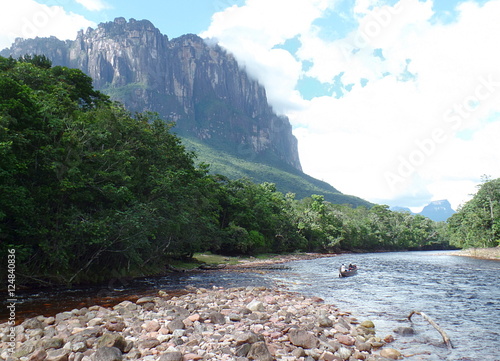 sailing downstream / one boat on the river Carrao, among the huge tepuis of Venezuela's Gran Sabana

