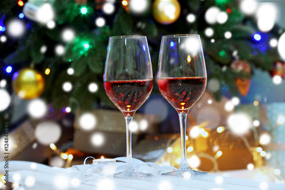 Glasses of red wine on blurred Christmas interior background. Christmas celebration concept. Glasses of red wine on blurred Christmas interior background. Christmas celebration concept.