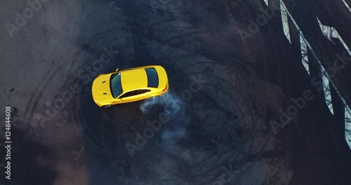 Top view of the golden car drifting on the road. Car makes a few laps. Shooting with a drone in 4k. photo