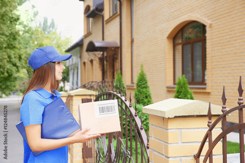 Female courier in uniform delivering parcel outdoor Female courier in uniform delivering parcel outdoor