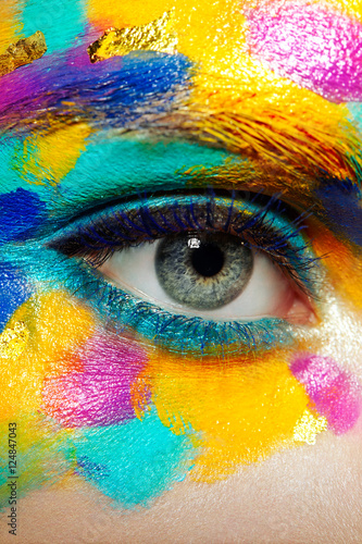 Beautiful woman face. Beauty girl face with colorful makeup. Beauty fashion. Eyelashes. Red lipstick. Cosmetic Eyeshadow. Make-up detail. Rainbow Colors