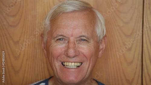 Senior man smiling and showing his false teeth.