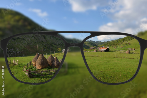Clear image in glasses against blurry landscape