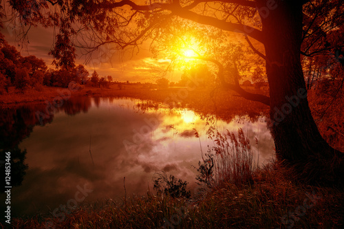 Rural landscape with lake at magical orange sunset © vvvita