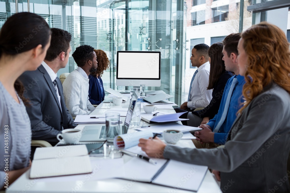 Business people looking at a screen during a video conference Business people looking at a screen during a video conference