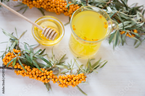 tea with sea buckthorn and honey on a light background.