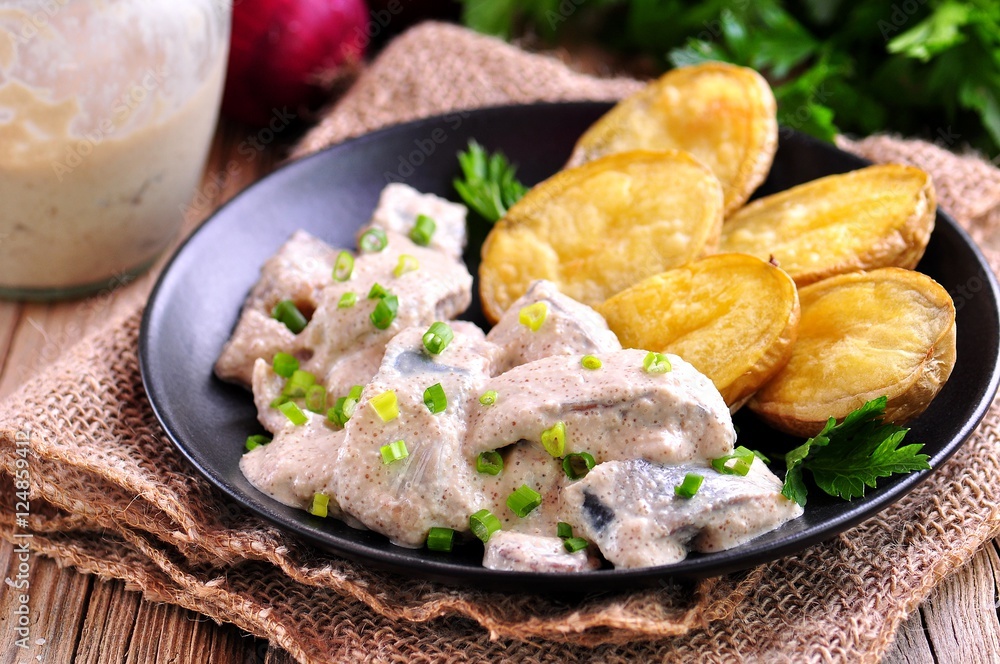 Salted herring marinated in white caviar sauce with baked potatoes.