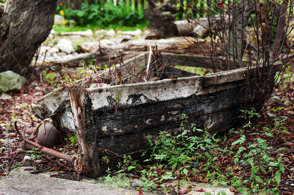 Fototapeta premium Last place of old broken boat in autumn garden.