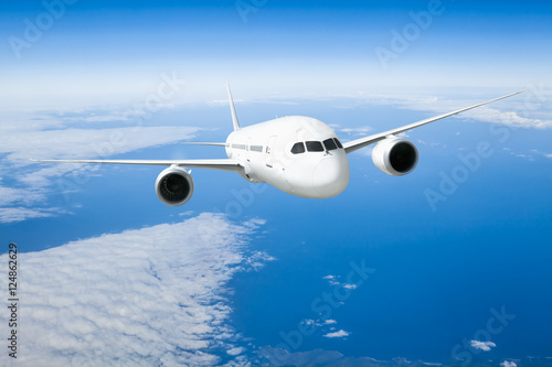 Podróż samolotem, samolot latający w błękitne niebo nad chmurami