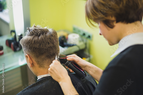 Professional barber styling hair of his client