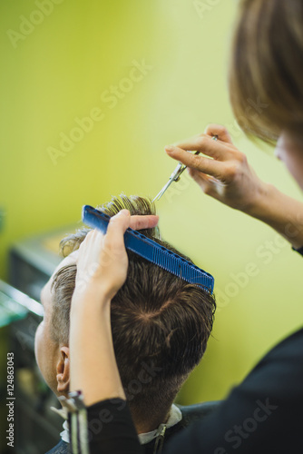 Professional barber styling hair of his client