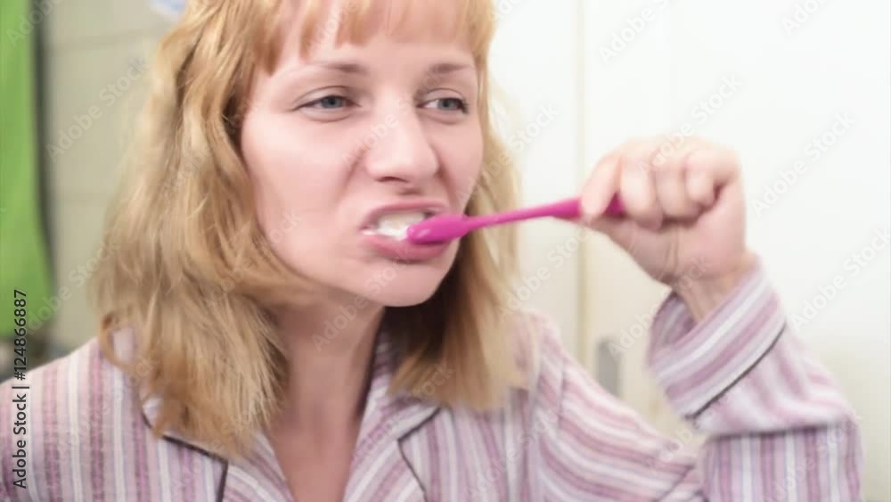 Portrait of happy woman cleaning her oral cavity caring about dental health. Pretty young female while brushing teeth in bathroom. Portrait of happy woman cleaning her oral cavity caring about dental health. Pretty young female while brushing teeth in bathroom.