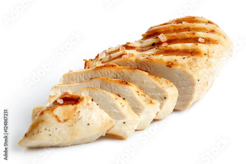  Partially sliced grilled chicken breast with black pepper and rock salt.