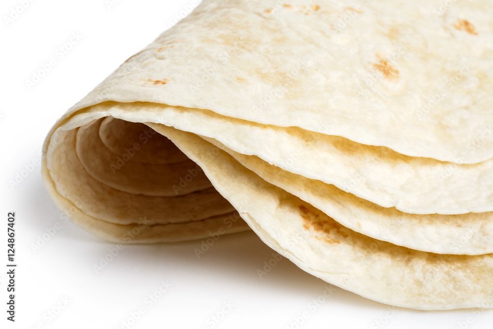 Detail of stack of folded tortilla wraps on white.