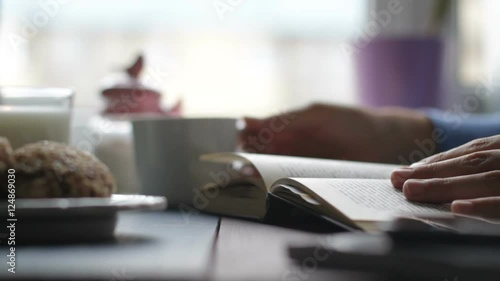 The girl was looking through a book in a cafe