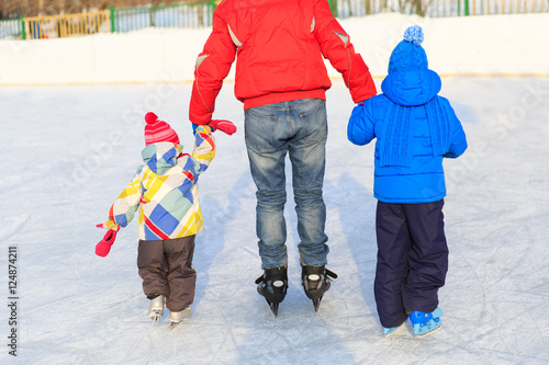father with two kids skating, family winter sport