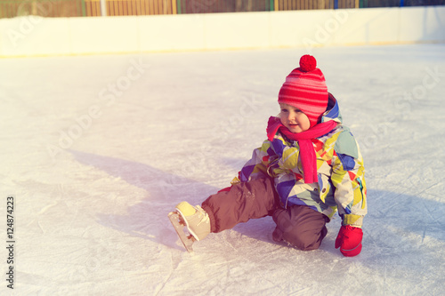 cute little girl learning to skate in winter