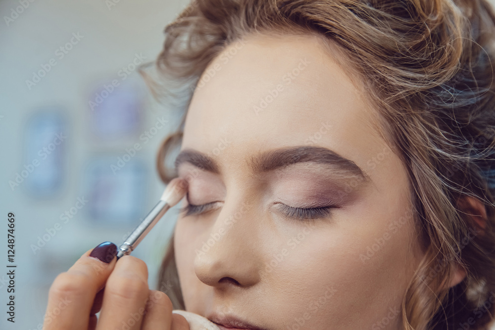 Make up artist doing professional eye makeup of young woman Make up artist doing professional eye makeup of young woman