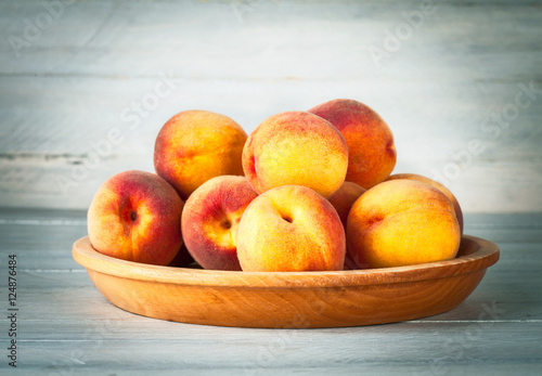 Fresh peach on wooden plate and board