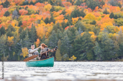 Happy couple canoeing in a lake in Canada