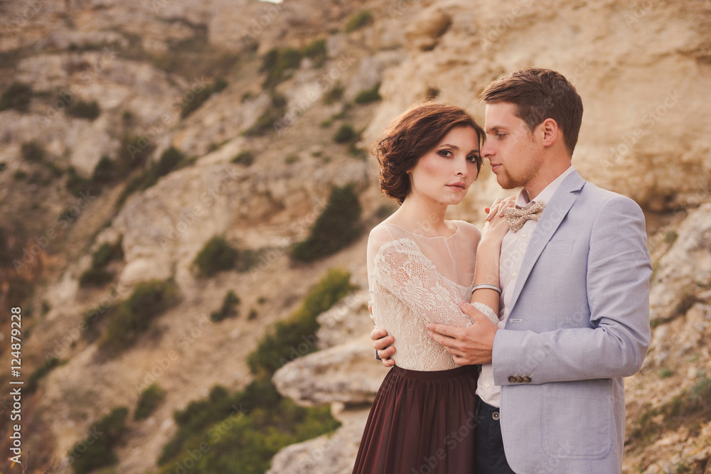 Romantic and stylish caucasian couple hugging on the background of spectacular view. Love, relationships, romance, happiness concept. Romantic and stylish caucasian couple hugging on the background of spectacular view. Love, relationships, romance, happiness concept.