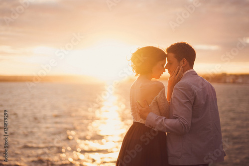 Romantic and stylish caucasian couple hugging at sunrise. Love, relationships, romance, happiness concept.