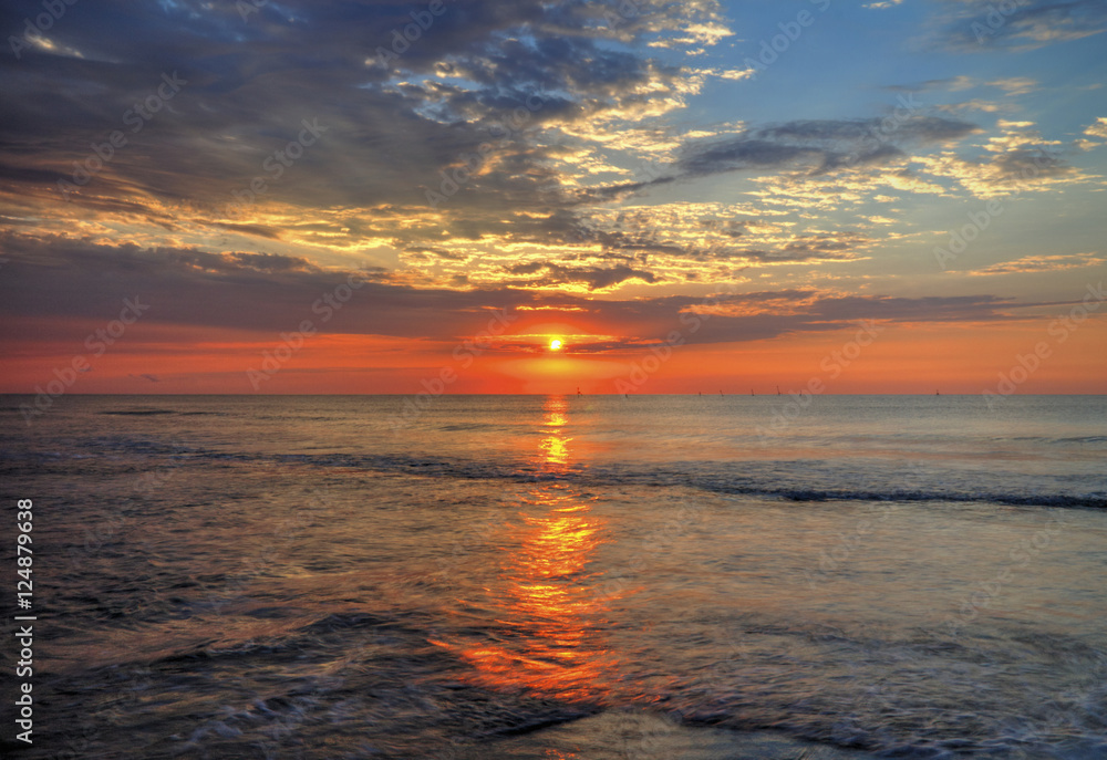Fototapeta premium Beautiful sunrise over the sea with dramatic clouds on the sky