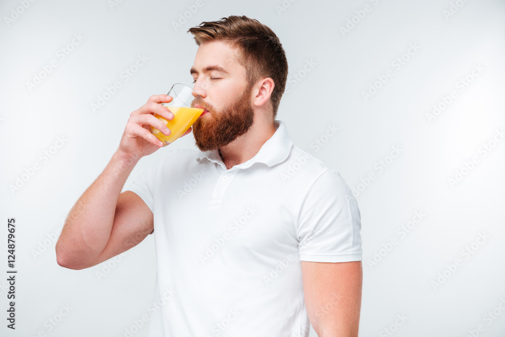 Young handsome bearded man drinking orange juice Young handsome bearded man drinking orange juice