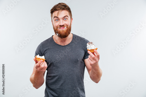 Happy smiling bearded man eating cream cake