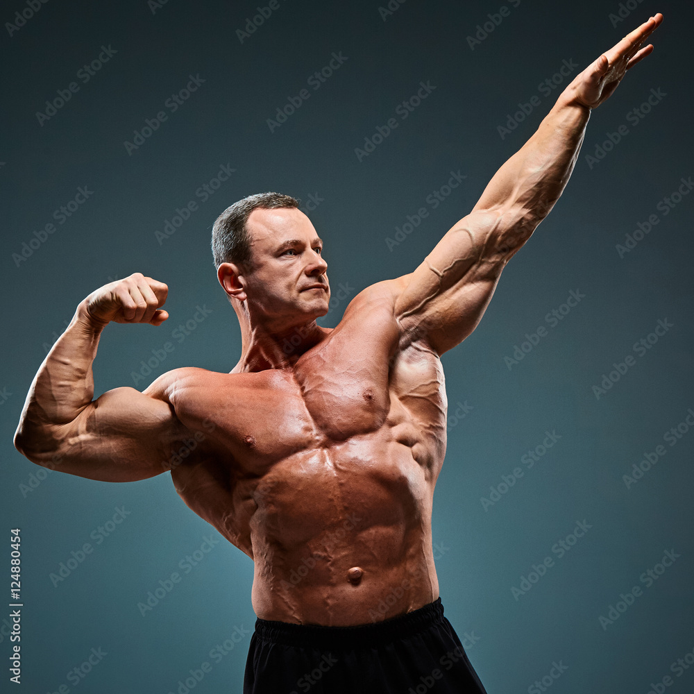 torso of attractive male body builder on gray background. Stock Photo