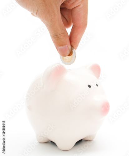hand putting a coin into piggy bank