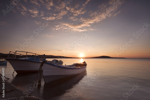 Two traditional wooden fishing boats in the sea. Fishing boats tied up in harbor at the end of the day. Sunset near the Black Sea coast © sevdastancheva