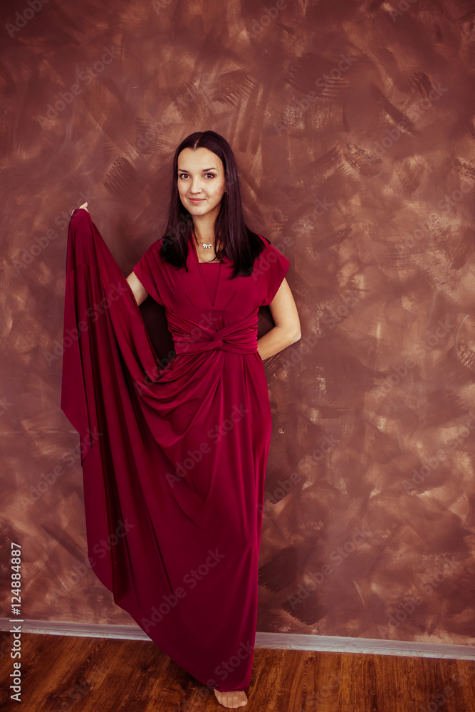 Radiant brunette poses in wine dress