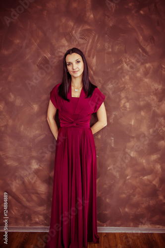 Gorgeous woman hides her hands while posing in wine dress © pyrozenko13
