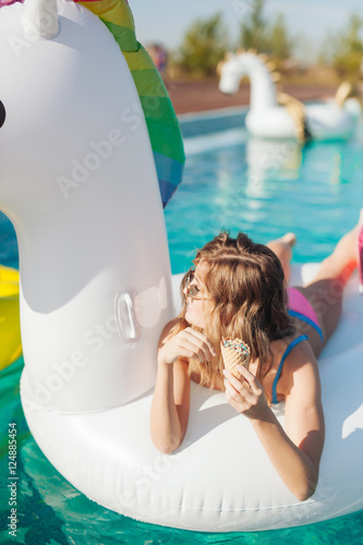 sexy girl in sunglasses eating ice cream in pool 20s.