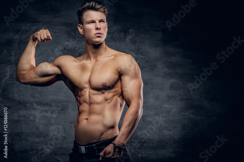 Shirtless athletic male showing biceps.