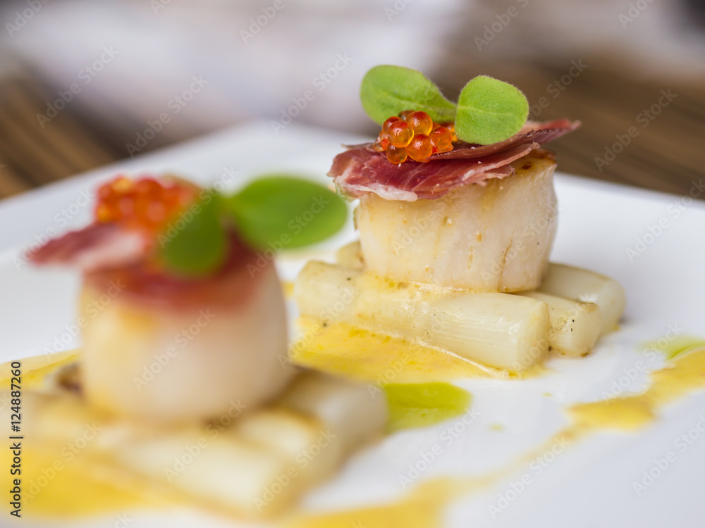 Seared scallops with salmon roe, ham and asparagus on plate Seared scallops with salmon roe, ham and asparagus on plate