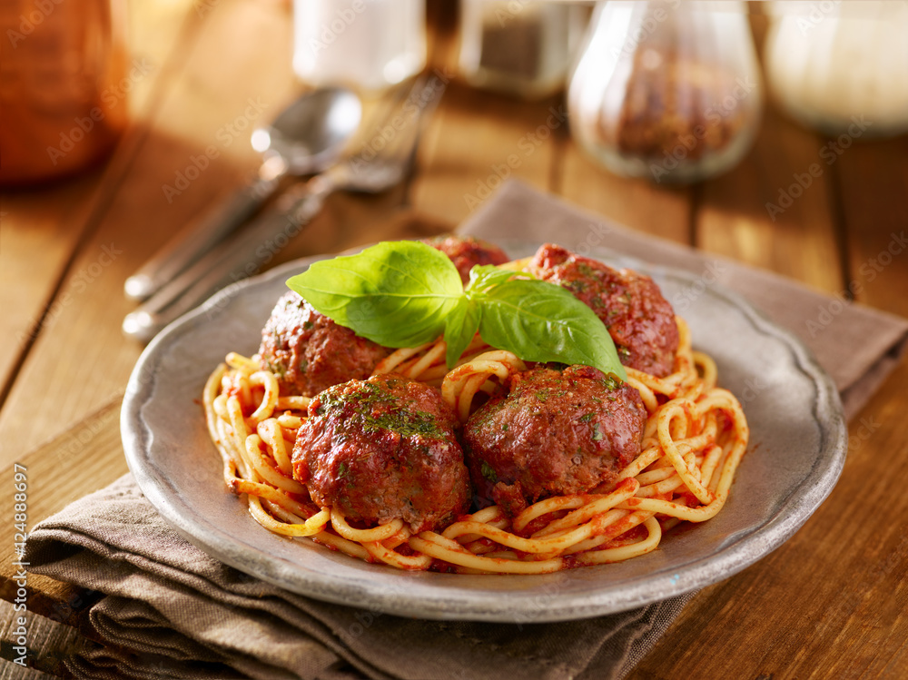 spaghetti and meatballs dinner with basil garnish