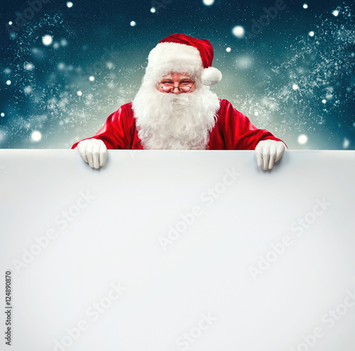 Santa Claus holding blank advertisement banner background with copy space photo