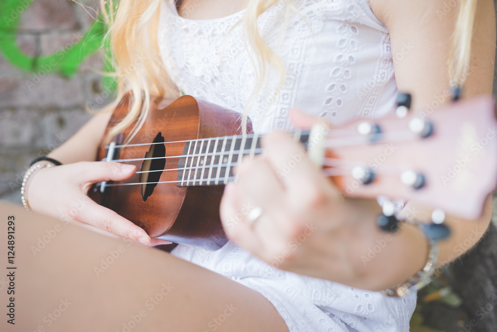 Fototapeta premium Close up hand young millennial caucasian woman playing ukulele - music, song, chord concept