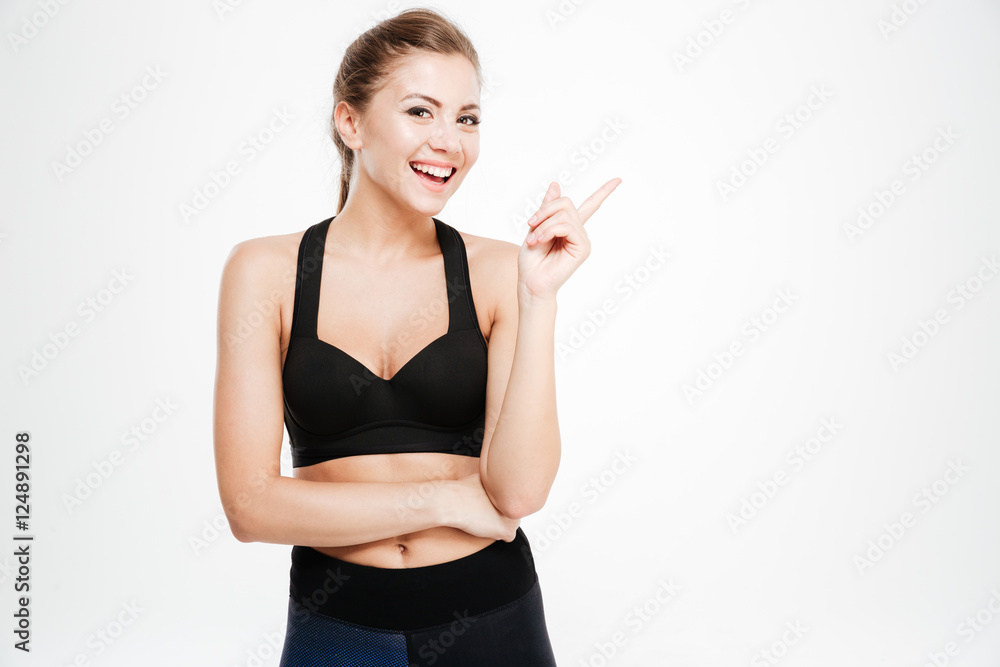 Portrait of a happy fitness woman pointing finger up Portrait of a happy fitness woman pointing finger up