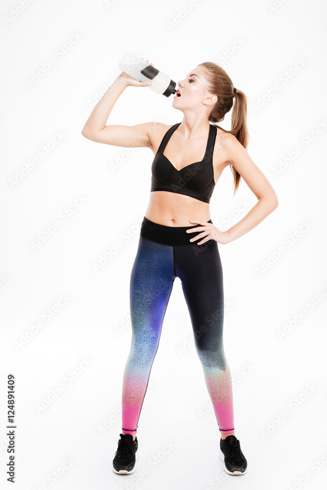 Full length portrait of a beautiful sports woman drinking water Full length portrait of a beautiful sports woman drinking water