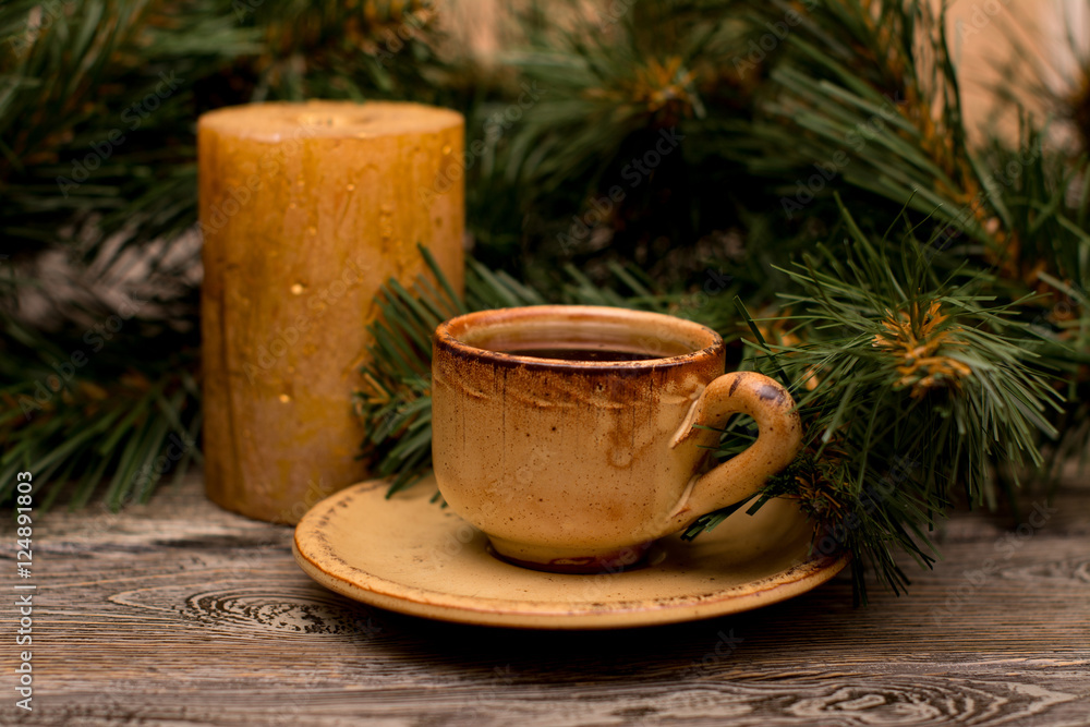 Fototapeta premium Small cup of coffee, fir branch and candle on wooden background